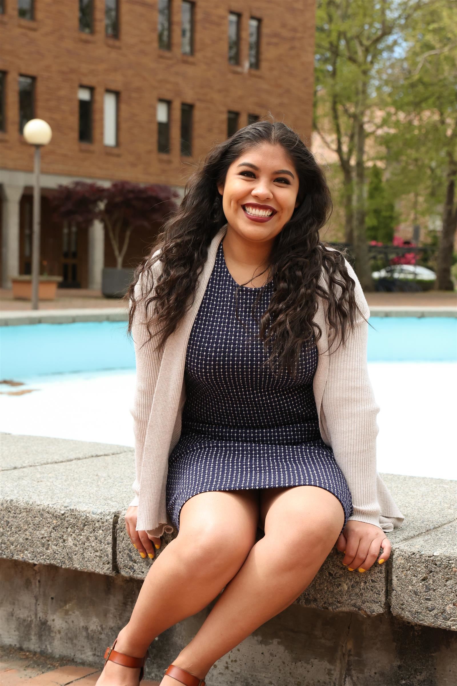 Ms. Sanchez sitting outside in front of a fountain 