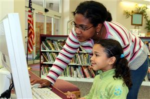 Volunteer helping student on computer 