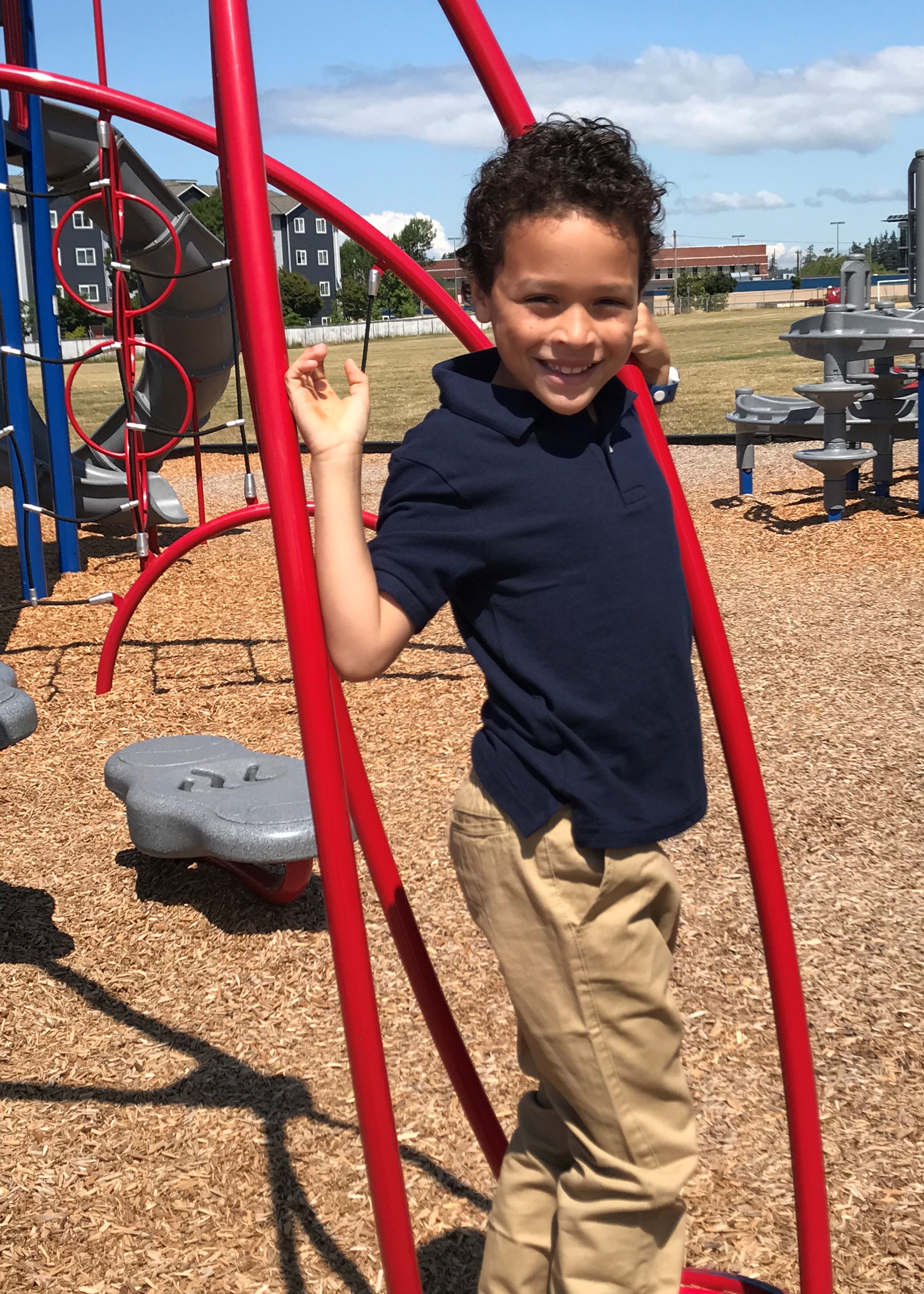 boy in uniform-navy collared short sleeved shirt and tan long pants 